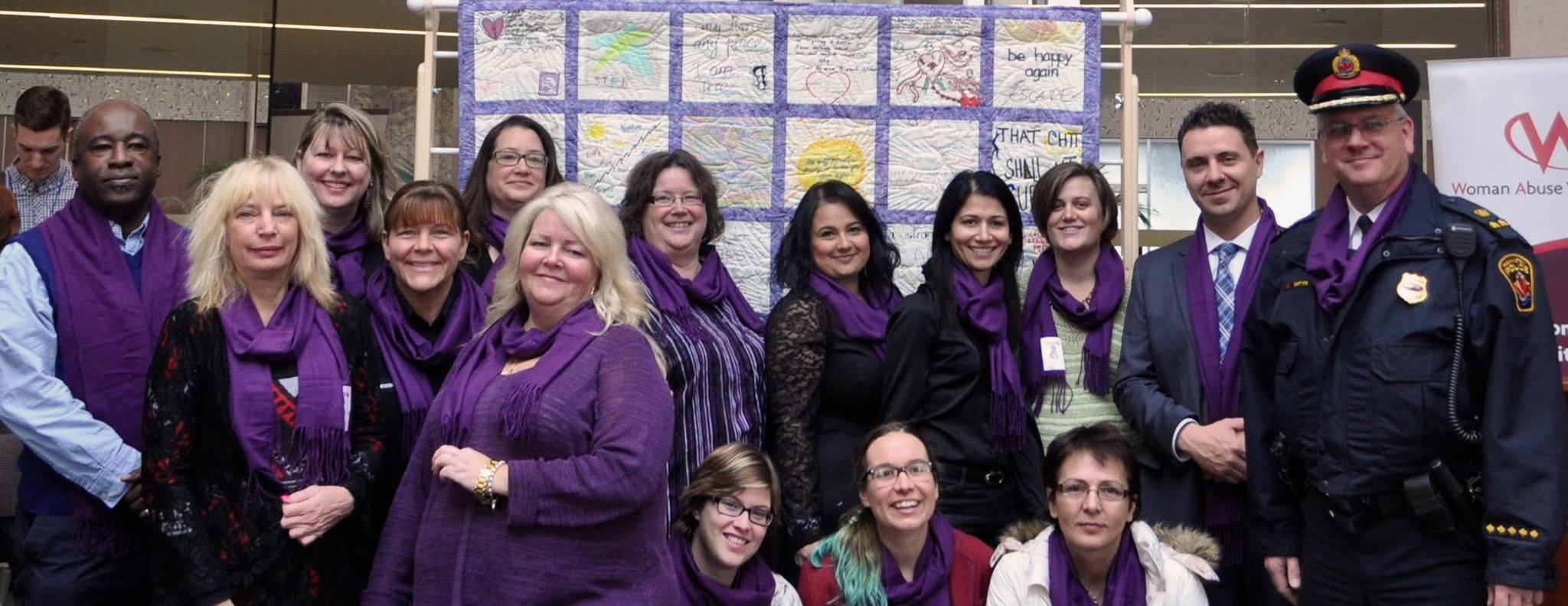 Image of the Woman Abuse Working Group members. They are all wearing the purple scarves to show their support for abused woman and children across Canada
